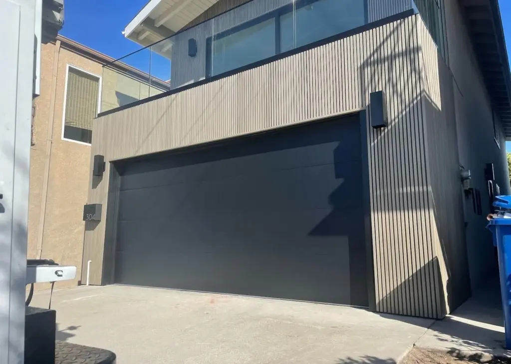 Modern black flush panel garage door installed by Perfection Garage Door