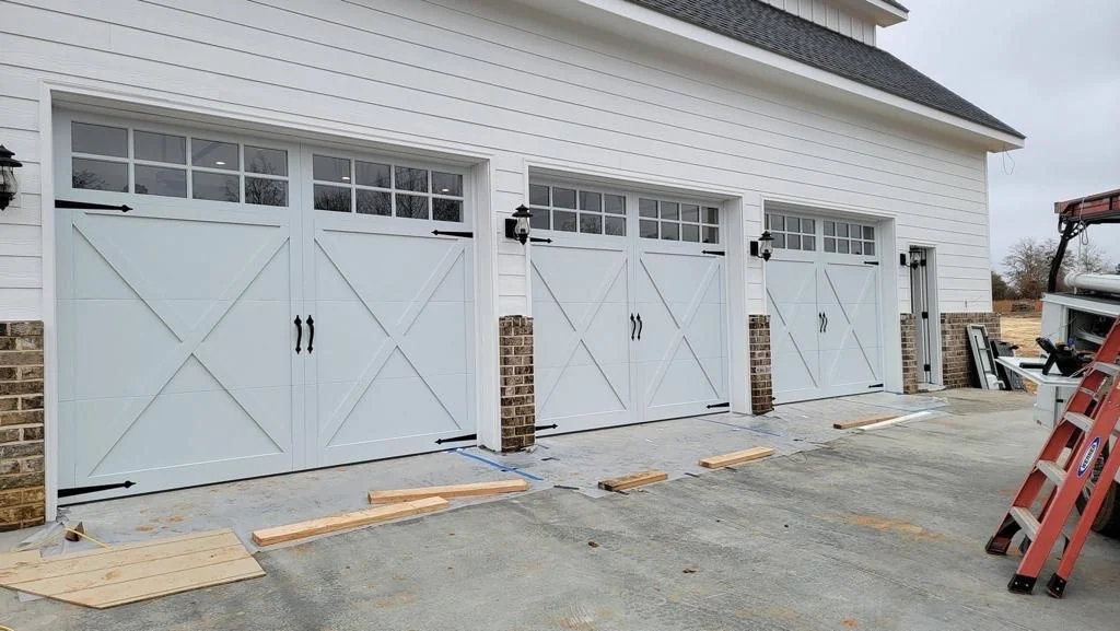 Three white carriage style garage doors installed by Perfection Garage Door